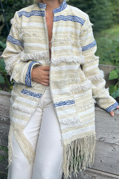 Nahaufnahme der aufgesetzten Taschen und Fransenstreifen der Boho Jacke Aglaie

Meta: Detailfoto der handgewebten Taschen und Bordüren der Jacke Aglaie.
